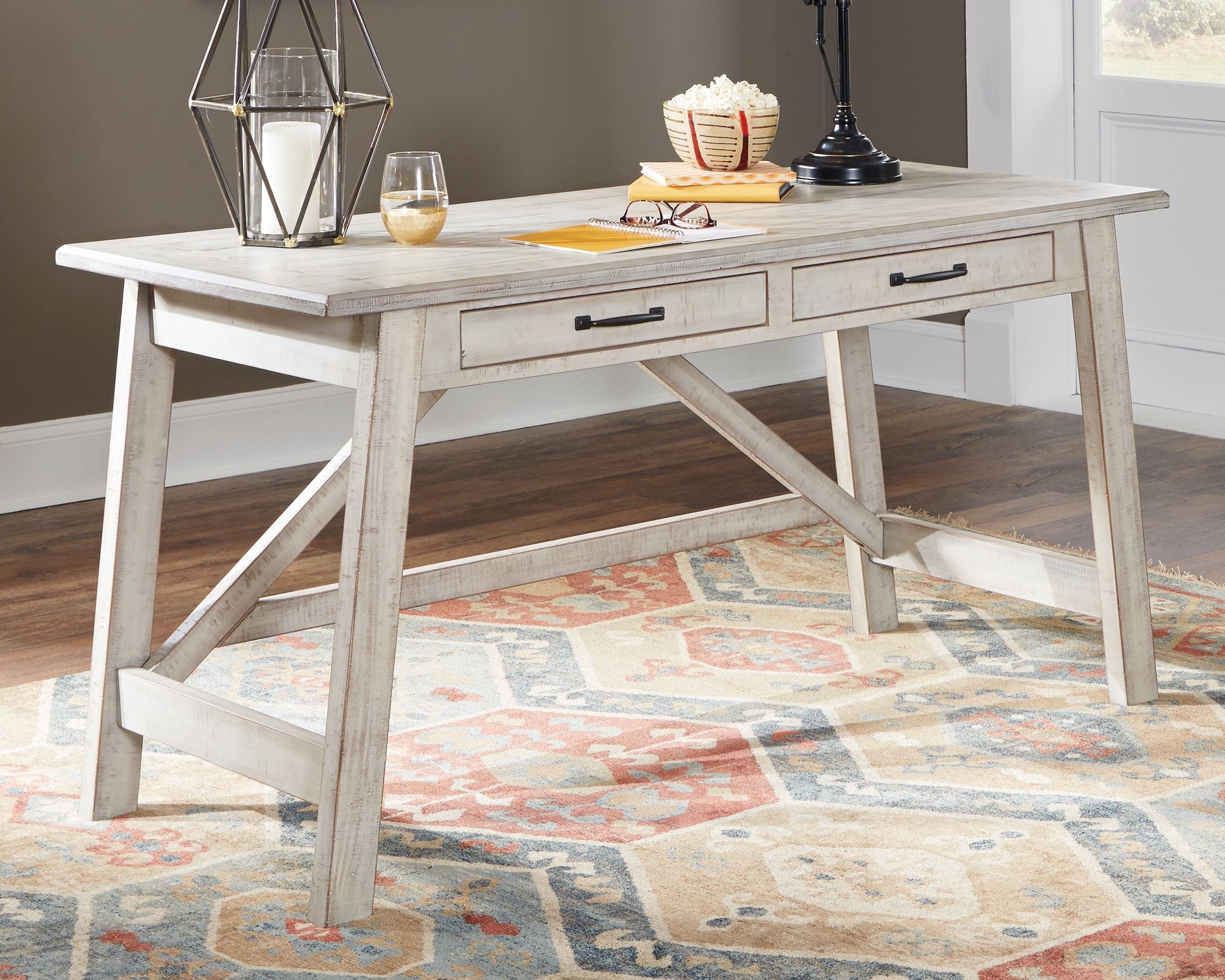 White farmhouse writing desk with drawers in a rustic home office