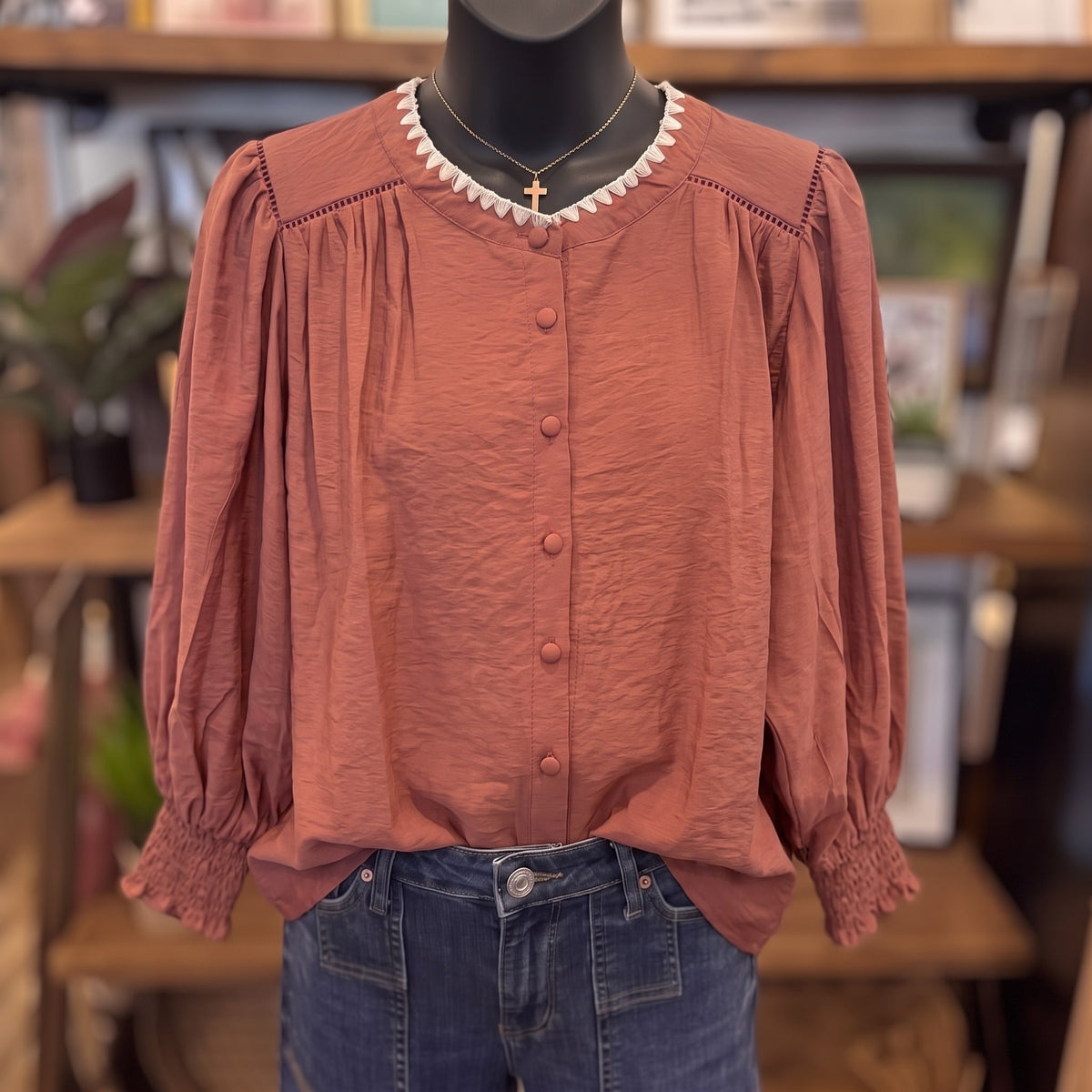 Contrast Stitch Button Down Top in maroon on a mannequin, front view, showing the cream zigzag neckline trim and covered buttons